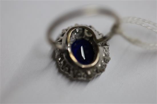 A modern white gold?, sapphire and diamond set oval cluster ring, size N.